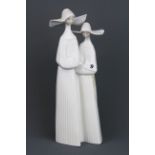 A glazed Lladro porcelain figure of two Nuns, H. 33cm. Condition: no visible damage or repair.