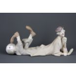 A Lladro bisque clown figure, L. 36cm, H. 16 cm.