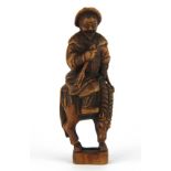 A finely carved fruitwood netsuke of a man riding a horse, H. 9cm.