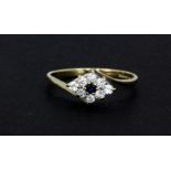 A 9ct yellow gold sapphire and white stone set cluster ring, (N.5).