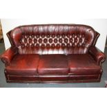 A three piece ox blood leather button backed suite including one rocker armchair.