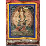 A Tibetan silk mounted hand painted Thangka of a multi headed guardian deity, W. 79cm, H. 101cm.