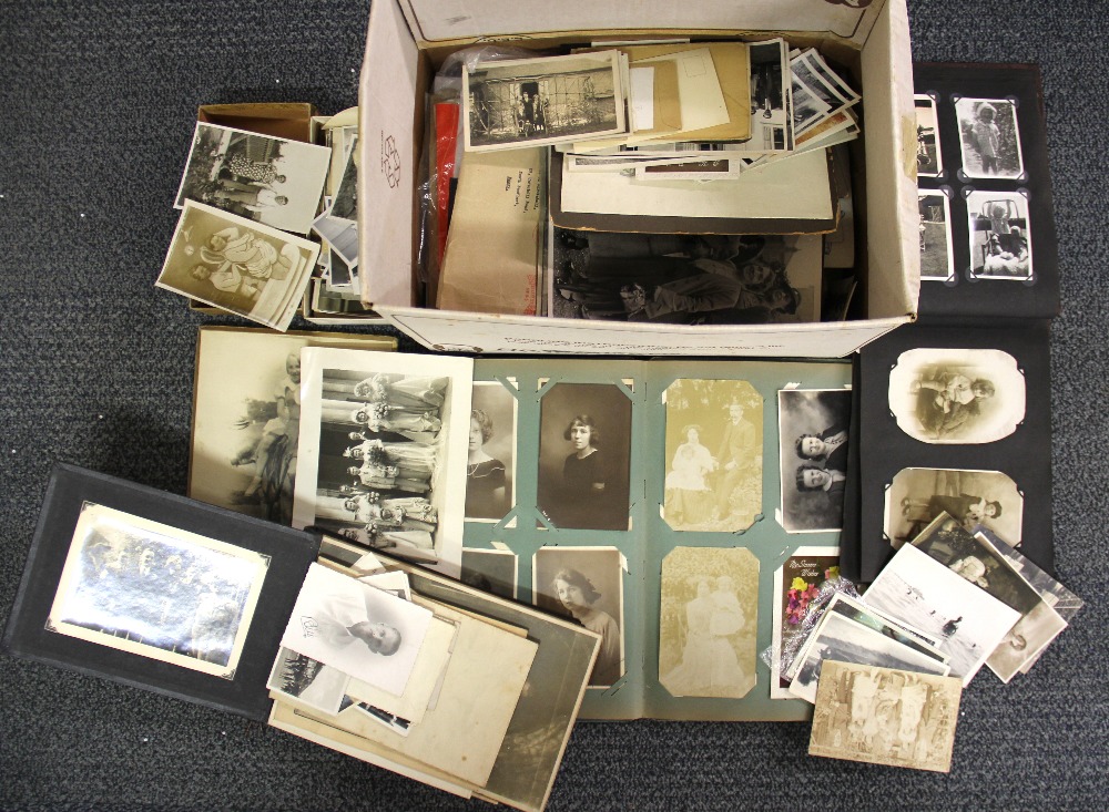 A 1920's album of postcards and photographs, together with a large quantity of vintage photographs.