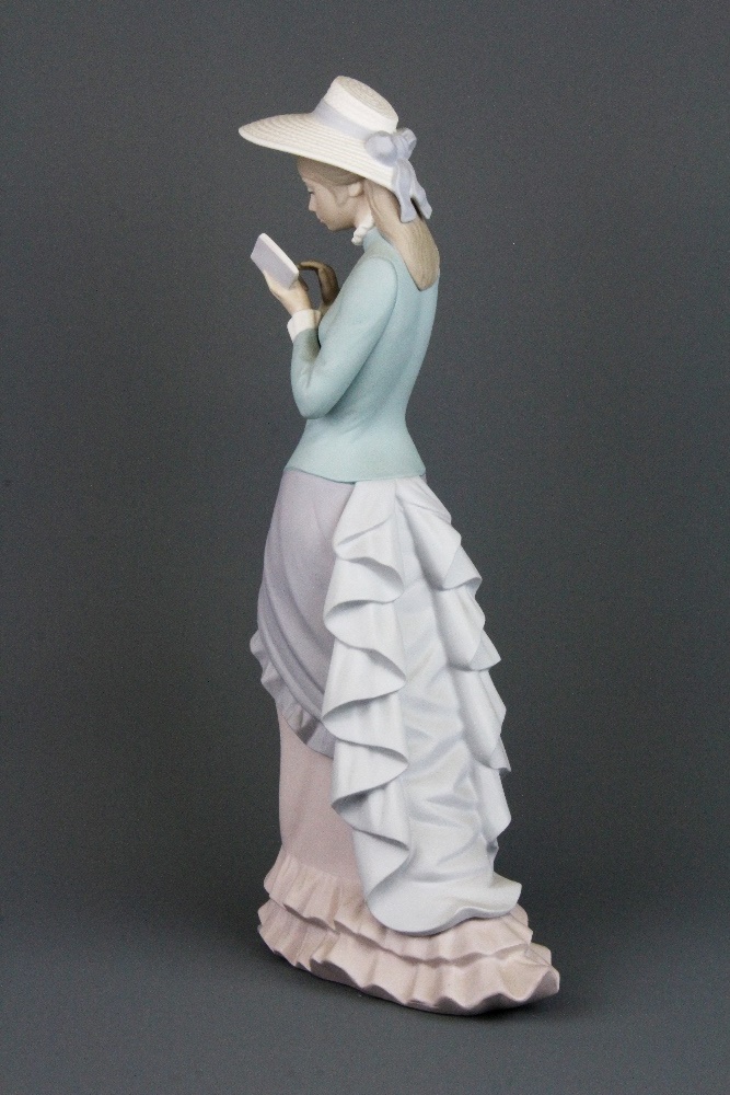 A Lladro bisque porcelain figure of a lady reading a book, H. 36cm.