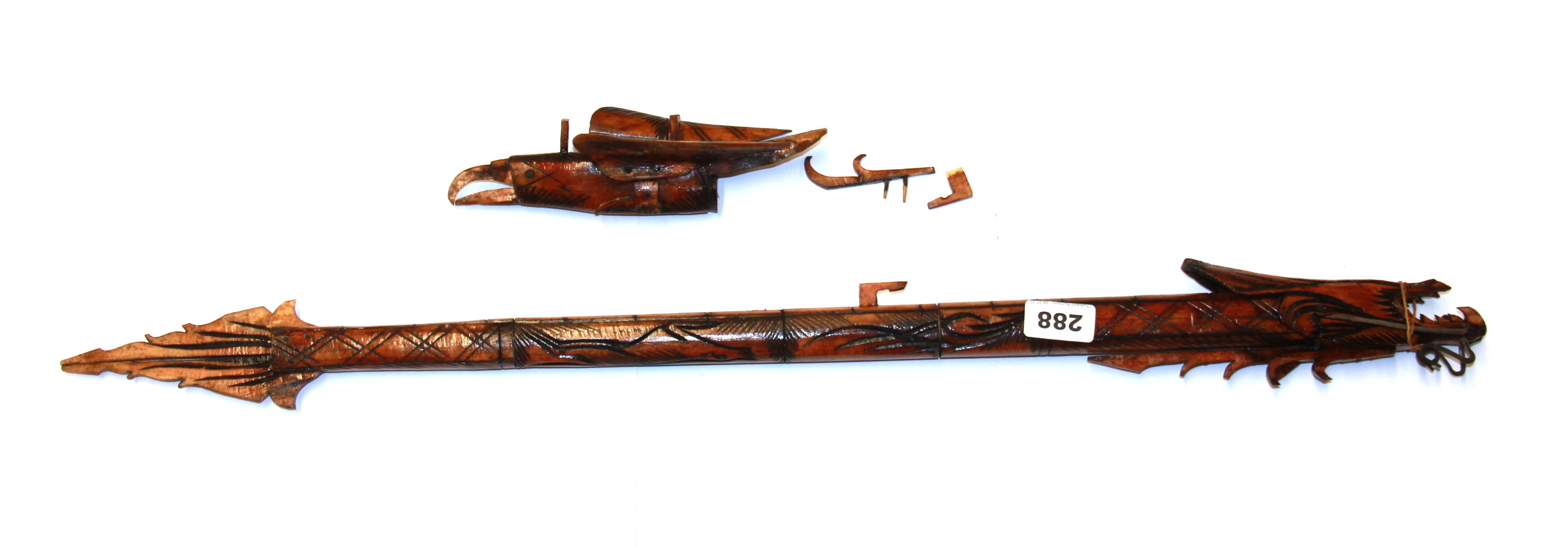 An Indonesian carved bone dragon and bird blow pipe, full L. 77cm.