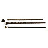 A brass handled walking cane and two others.