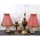 A brass oil lamp, a brass table lamp and two porcelain lamps.