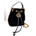 A Gucci Marmont velvet bucket handbag with carrying bag and original label and carrier bag.