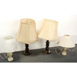 A pair of turned wood table lamps with a pair of onyx table lamps.