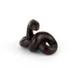 A carved fruitwood netsuke of a snake with black onyx eyes, W. 4.6cm H. 3.2cm.