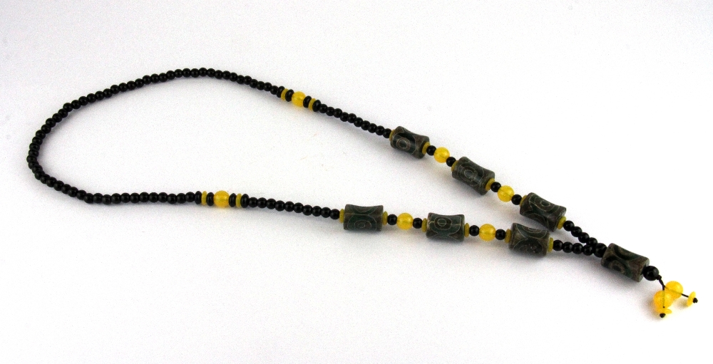 A Tibetan prayer bead necklace of dzi beads, yellow agate and obsidian, folded L. 43cm.