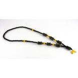 A Tibetan prayer bead necklace of dzi beads, yellow agate and obsidian, folded L. 43cm.