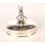 A small white metal (tested silver) pill box mounted with an articulated rabbit, W. 4cm.