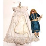 A Victorian wax head and composition doll with original silk dress, together with a Christening robe