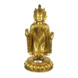 A Tibetan gilt bronze standing figure of the robed Buddha, H. 34cm.