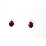 A pair of 18ct white gold (stamped 18k) stud earrings set with oval cut rubies and diamonds, L.