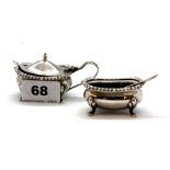 Two hallmarked silver salt and mustard pots and spoons with blue glass liners.