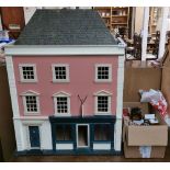 A large hand made wooden shop dolls house, H. 90cm, W. 74cm, with a large quantity of furniture