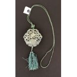 A lovely Chinese carved jade amulet on a faded green silk cord, Dia. 6cm.