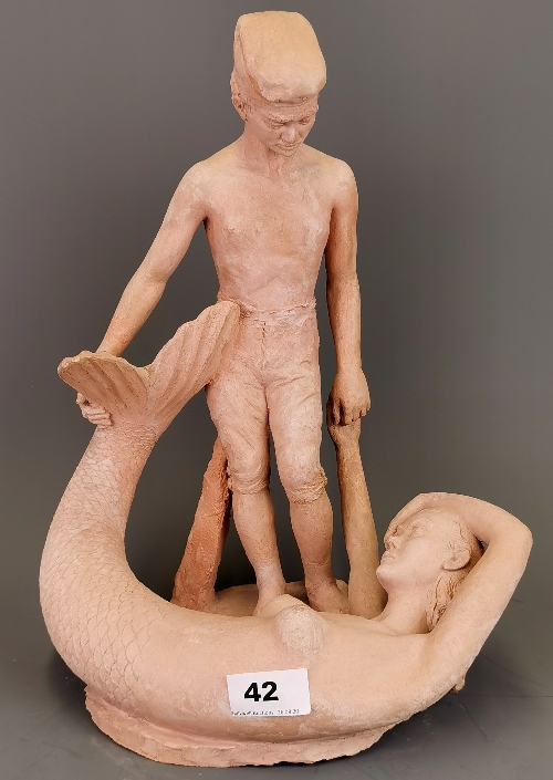 An interesting hand made pottery figure of a boy with a mermaid. H. 35cm.