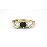 A 9ct yellow gold three stone ring set with blue spinel and white stones, (N).
