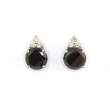 A pair of 18ct white gold (stamped 750) stud earrings set with a 3.30ct black diamond with 0.20ct of