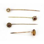 Four 9ct yellow gold stone set stick pins.