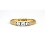 An 18ct yellow gold diamond set three stone ring, (L).