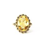 A 9ct yellow gold (faded hallmark) ring set with a large oval cut citrine, (L).