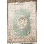 A large Chinese washed wool carpet with green ground. W. 277.