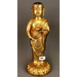 A large Tibetan gilt bronze figure of a standing Buddha. H. 39cm.