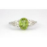 A 9ct white gold peridot and white stone set ring, (N.5).