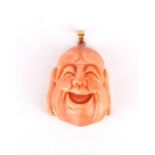 An 18ct gold mounted (stamped 18k) carved coral happy Buddha head. H. 4cm.