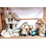 A large Pendelfin model cottage with a fruit shop, a further cottage and three large figures,