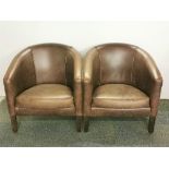 A pair of leather upholstered and fabric backed tub chairs.