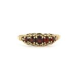 A 9ct yellow gold ring set with garnets, (0.5).