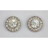 A pair of white metal (tested 18ct gold) diamond set halo stud earrings, approx. 1ct.