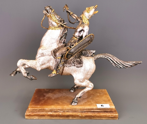 A silvered and gilt heavy metal figure of a Viking riding a horse (figure detachable) set on a brown