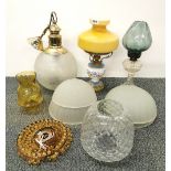 An oil lamp and a group of glass shades.