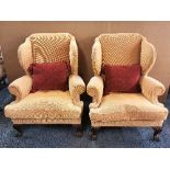 A pair of good quality re-upholstered wing back arm chairs with lions paw feet.