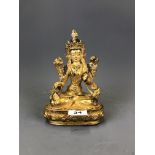 A Tibetan gilt bronze and hand painted figure of a seated Tara, H. 20.5cm.