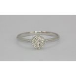 A 9ct white gold diamond set daisy ring, (N.5).