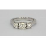 An 18ct white gold (stamped 750) ring set with three brilliant cut diamonds, approx 1ct, (M).