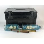 A Military ammunition case with a brass telescope and two ships in bottles.