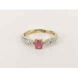 A 9ct yellow gold ring set with a ruby and diamond shoulders, (L).