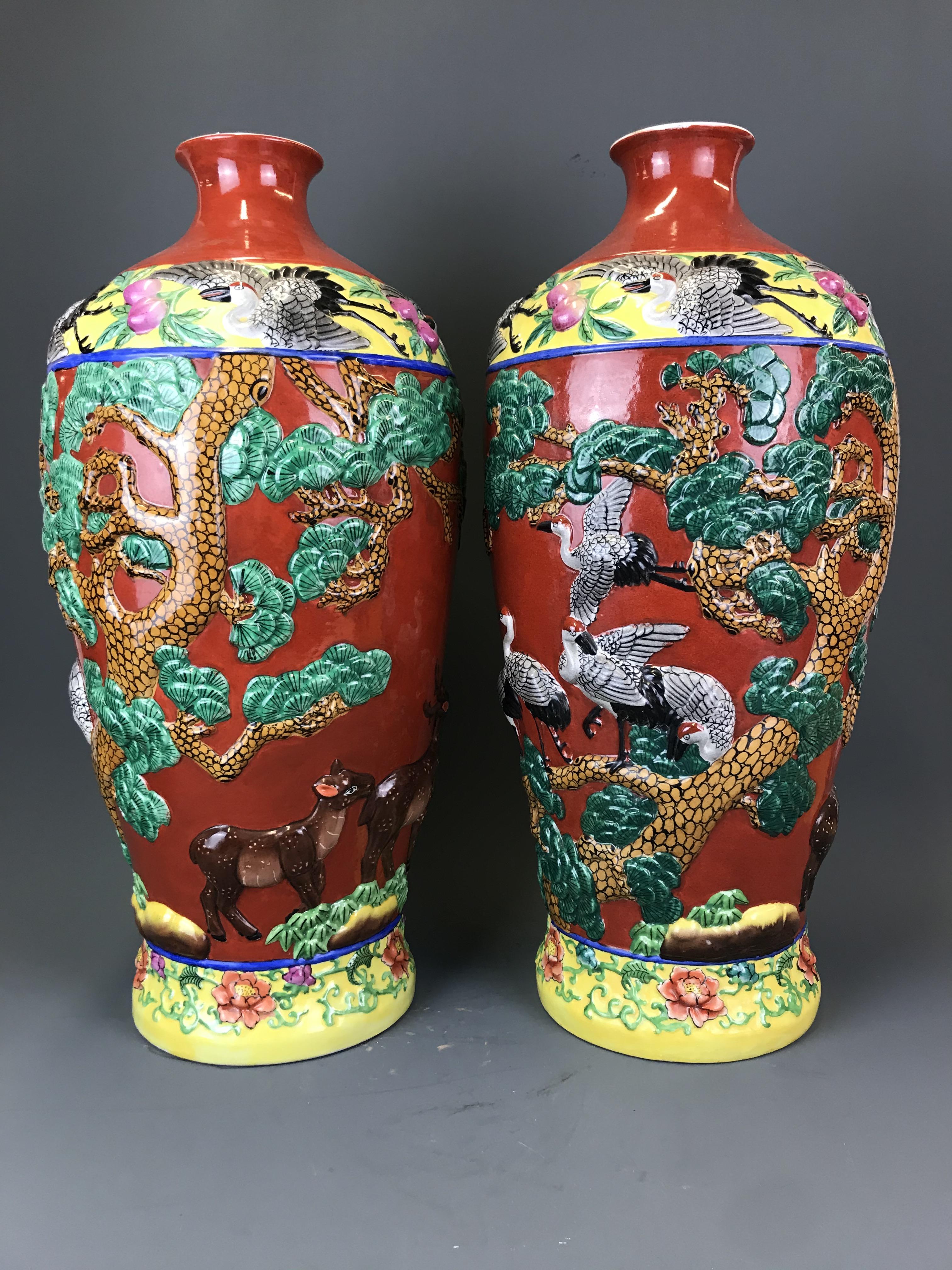 A pair of large 20th Century Chinese relief decorated and hand painted porcelain vases, H. 58cm.