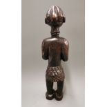 An African carved Punu Tribal fertility figure of a woman feeding a baby, H. 42cm.