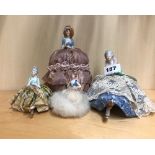 Four porcelain half doll pin cushions including one with a Swans Down 'puff' skirt, tallest 17cm.
