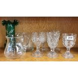 Five Victorian pressed glass wine goblets and other glass items.