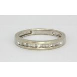 A 10ct white gold (stamped 10K) diamond set half eternity ring, (N).